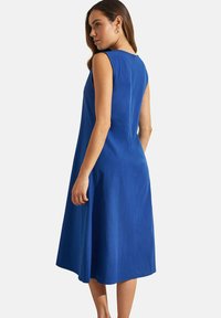 Robe sans manches bleue avec une coupe décontractée, longueur au genou et une fermeture éclair au dos. Tissu lisse avec un léger éclat et sans motifs visibles.