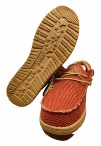 Röda vävda tygskor med en beige gummiyttersula som har stjärnmönstrad profil och dekorativ sömnad längs kanten.