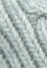 Tessuto in lana lavorata a maglia di colore grigio chiaro con un motivo a coste testurizzato e fibre visibili, che mette in mostra un aspetto morbido e caldo.