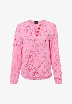 Pink long-sleeve blouse with red handwritten script pattern and a small V-neck opening at the collar.