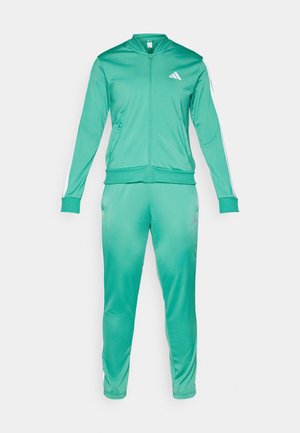 Survêtement vert en polyester lisse avec veste zippée, poignets côtelés et bandes blanches sur les côtés. Présente un logo sur le haut à gauche.