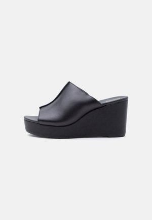 Svart skinn kilehæl sandal med åpen tå og påtrekksdesign, med høy, solid platåhæl.