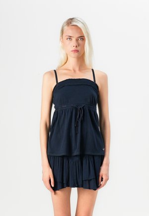 Søndagsblå ærmeløs kjole med smock-bodice, flæse nederdel i lag, justerbare stropper og snøre i taljen.