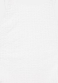 Robe blanche sans manches en tissu texturé avec taille smockée et décolleté carré.