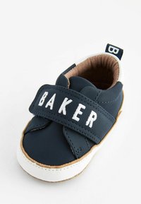 Navyblaue Lederbabysneaker mit einem breiten Riemen mit dem Text "BAKER", braunem Innenfutter, weißer Gummisohle und hellbraunen Akzenten.