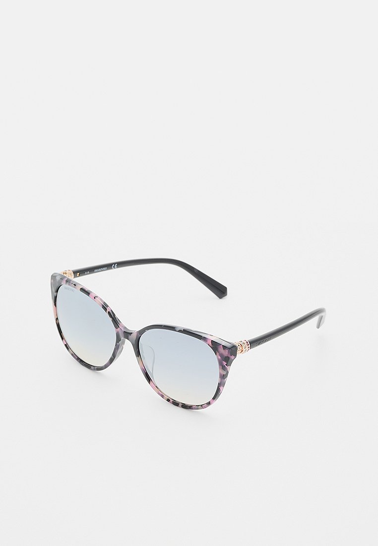 Lunettes de soleil en forme d'œil de chat avec un design écaille de tortue noir et rose, des verres dégradés et des accents décoratifs sur les branches.