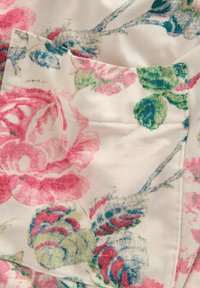 Cvetlični material z rožnatimi vrtnicami in zelenimi listi z modrimi akcenti na kremnem ozadju. Mehka tekstura z vidnimi šivi.