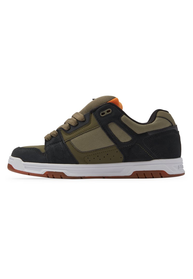 Sneaker design with olive green and black upper, featuring textured suede and mesh materials, white midsole, and orange accent on tongue.