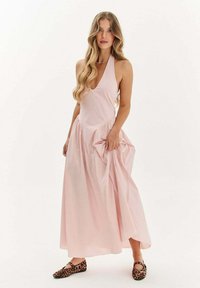 Ružová halter šaty s prúžkovanou sukňou a riasením na boku. V páre s balerínkami s leopardím vzorom na nohách.