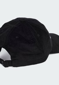 Gorro de pana negra con visera curvada, que presenta un tejido texturizado, correa ajustable en la parte trasera y orificios de ventilación.
