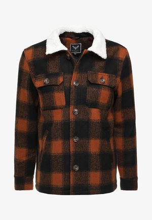 Giacca a quadri in misto lana nera e arancione bruciato, con colletto in pile bianco, due tasche sul petto e chiusura frontale con bottoni.
