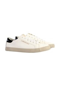 Zapatillas blancas de cuero con tacón negro, con punta redonda, cordones blancos y suela de goma beige. Texto en relieve en el lateral.
