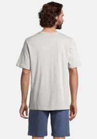 T-shirt in cotone grigio chiaro con maniche corte, collo rotondo e vestibilità comoda, visto da dietro. Abbinato a pantaloni corti blu.