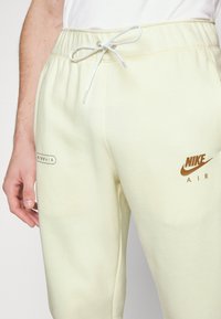 Nike Sportswear Calças de fato de treino - coconut milk/white/dark driftwood