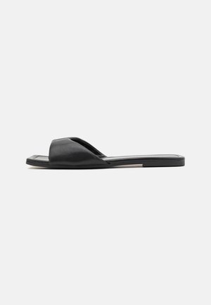 Sort slide-sandal med åben tå, glat lædermateriale og flad sål. Har et elegant design med minimalistiske accenter.