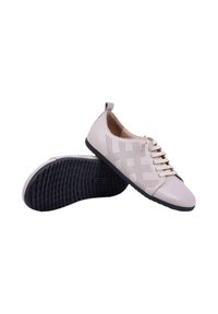 Chaussures en cuir beige clair décontractées avec un design perforé sur le côté, lacets à l'avant et semelles en caoutchouc noires texturées.