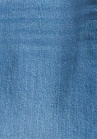 Tissu en denim bleu montrant une texture de tissage détaillée et de légères variations de couleur.