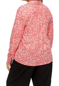 Czerwona i biała koszula w wzory z długim rękawem, kołnierzykiem i zaokrąglonym dołem. Lekka tkanina z wirującym abstrakcyjnym wzorem.