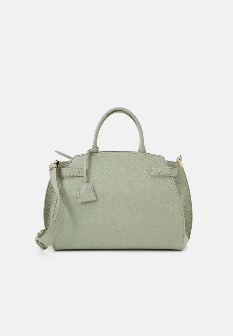 Petit sac à main en cuir vert à pois, avec deux poignées supérieures, une bandoulière amovible, des accessoires en métal doré et une forme rectangulaire.