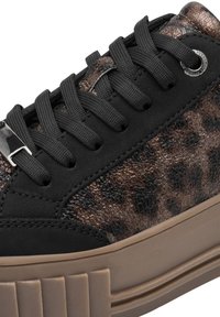 Baskets à imprimé léopard avec une tige en suède noir, des accents en cuir motif, des lacets noirs et une semelle en caoutchouc brun clair présentant des rainures verticales.