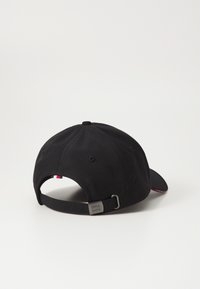 Cappellino da baseball nero in tessuto con visiera curva, cinturino regolabile e hardware in metallo, dotato di un piccolo tag rosso, bianco e blu.