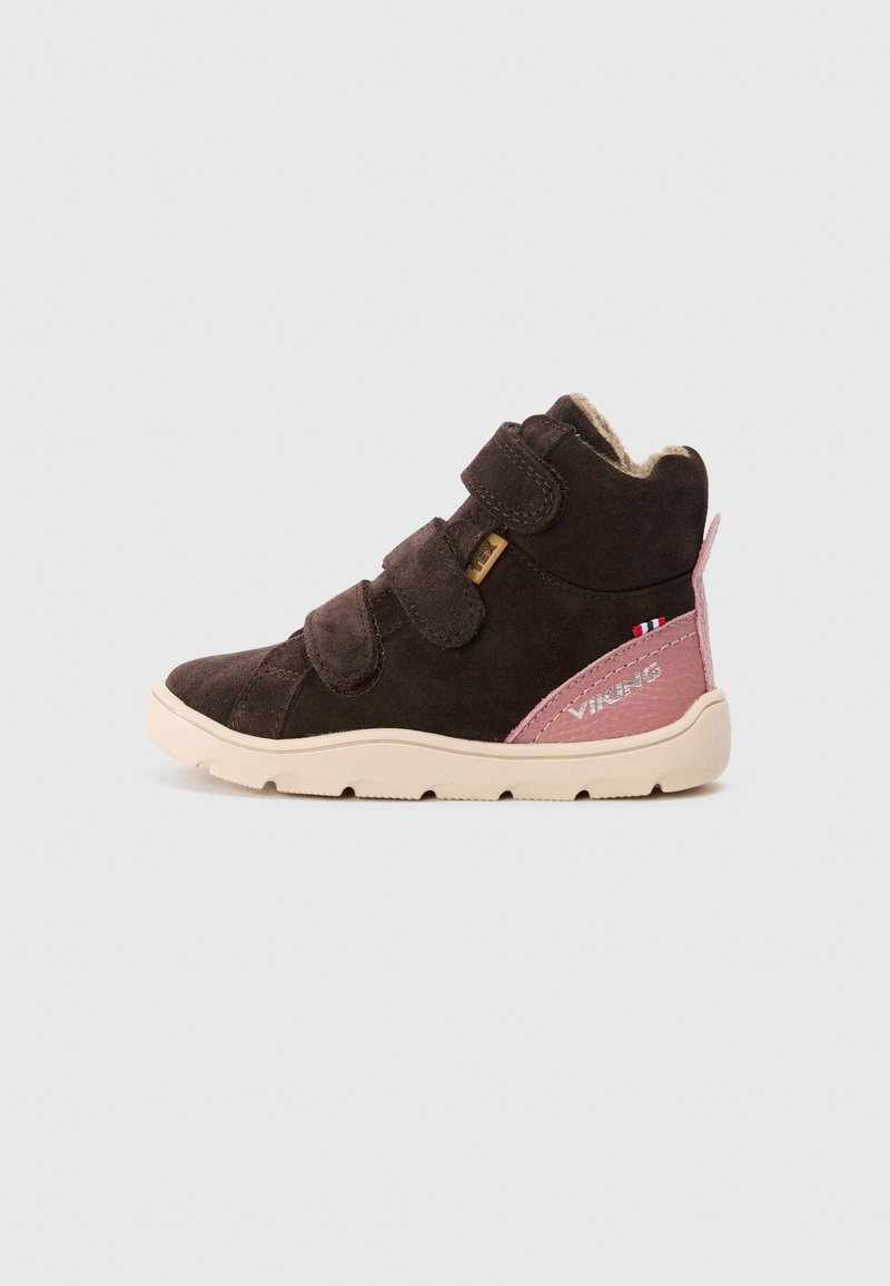 Zapato alto de ante marrón con acentos en rosa, que cuenta con dos correas de velcro y una suela de goma. Detalles notables de logo y costura en el lateral.