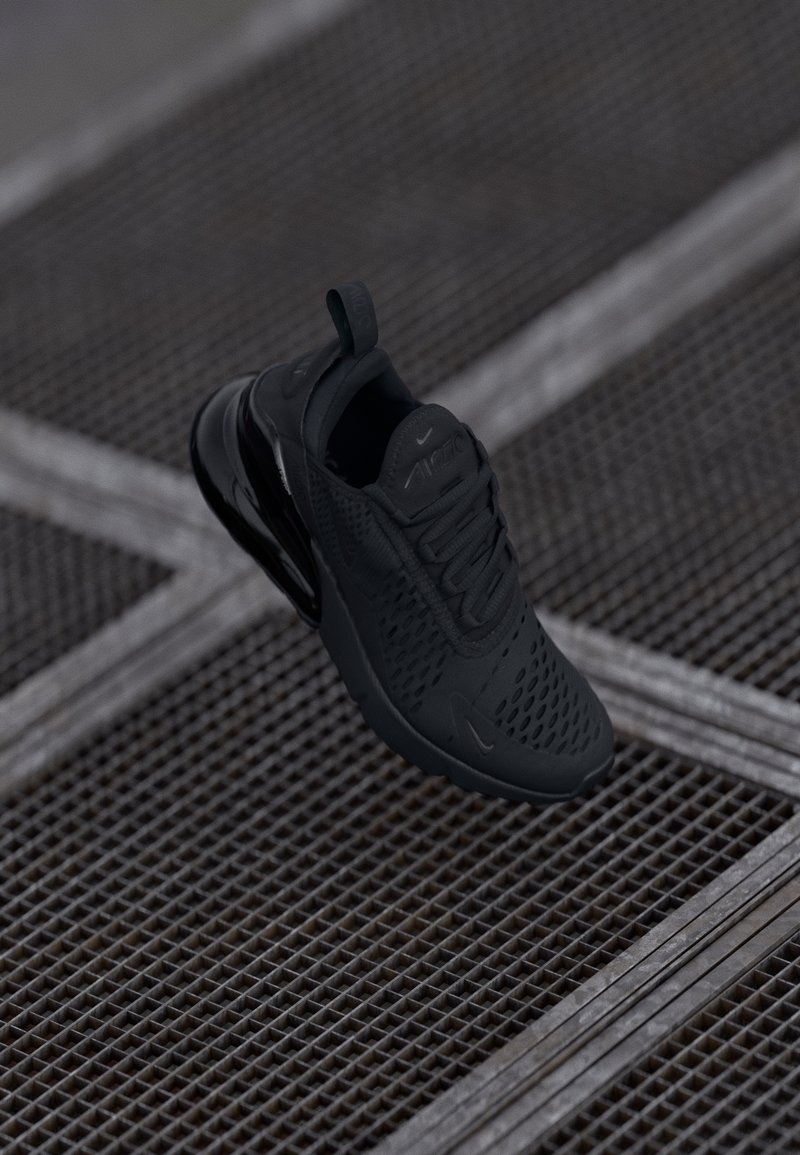 Schwarzer Sportschuh mit Mesh-Obermaterial, gepolstertem Kragen und Gummisohle. Verfügt über ein strukturiertes Muster und eine Zuglasche an der Ferse.