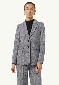 Karoblazer in Schwarz und Wei ß, mit strukturierter Passform, zwei Knöpfen, Reverskragen und seitlichen Taschen. Kombiniert mit passenden Hosen.