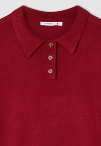 Czerwona koszulka polo z prążkowanym kołnierzykiem, z trzema guzikami i gładką fakturą. Metka wskazuje "Terranova", rozmiar S.
