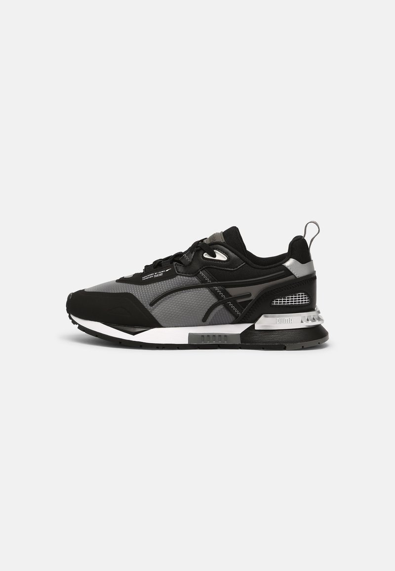 Baskets de sport noires et grises avec empeigne en mesh, semelle intermédiaire blanche, semelle extérieure noire, languette au talon et fermeture à lacets vues de côté.