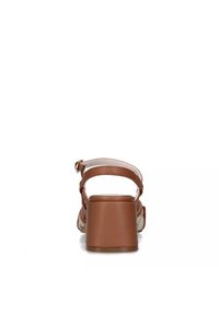 Sandali con tacco marroni, con un ampio tacco a blocco, cinturino posteriore e dettagli intrecciati sui lati. Parte superiore in pelle liscia e fodera morbida.