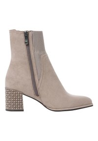 Bottine beige avec un talon bloc texturé, fermeture éclair sur le côté, en daim lisse et accents en tricot sur le dessus pour un ajustement flexible.