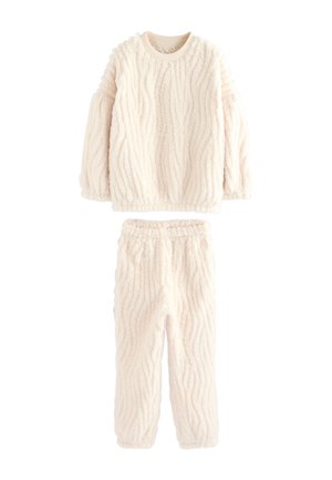 Crèmekleurige, zachte longsleeve top en bijpassende broek met een golvend, gestructureerd patroon, ontworpen voor warmte en comfort.