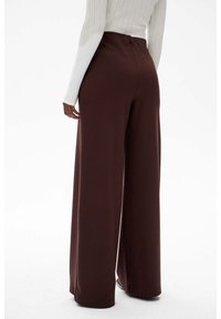 Brązowe szerokie spodnie wykonane z miękkiego materiału, z wysokim stanem i czystymi krawędziami, które zapewniają gładką sylwetkę.