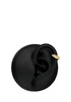 Black round display with a black ear model wearing a gold and diamond-studded double hoop earring on the upper ear.