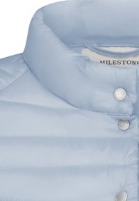 Hellblaue Steppjacke mit hohem Kragen, horizontal gestepptem Design und Druckknopfverschlüssen. Glatte, glänzende Stoffoberfläche sichtbar.