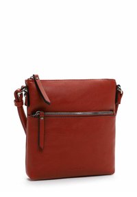 Červená kožená crossbody taška s přední kapsou na zip, hladkým povrchem a nastavitelným popruhem s odnímatelným akcentem.