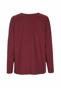 Långärmad topp i burgundy med rund halsringning och en avslappnad passform. Mjuk, slät tyg utan synliga mönster eller dekorationer.