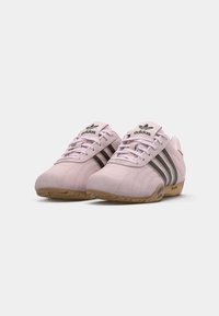 Sapatos de desporto em camurça rosa com design de três riscas pretas, biqueira arredondada e sola de borracha. Apresenta língua e atacadores acolchoados.