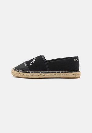 Svart kanvas espadrille med en vevd jutesåle. Har hvit logo tekst og en teksturert overdel. Slank design med rund tå.