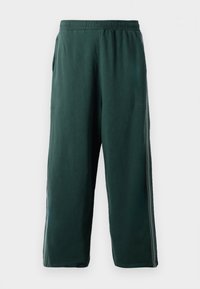 Dark green jogger pants made of soft fabric, featuring an elastic waistband, side pockets, and subtle side stripes for added detail.