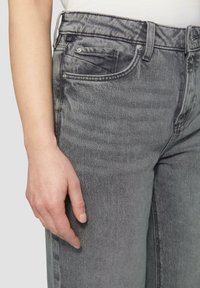Ausgebleichte graue Jeans mit geradem Bein, im Fünf-Taschen-Stil und robuster Naht. Sie verfügen über einen Metallknopf und einen Reißverschluss.