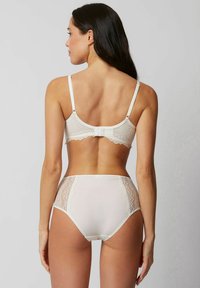 Witte kanten bh met verstelbare bandjes en haaksluiting, gecombineerd met een hoge taille slip met kanten zijpanelen en een gladde voorkant.