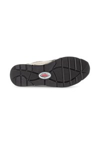 Die Schuhsohle besteht aus einem strukturierten schwarzen Gummi-Material mit einem gerippten Muster, einem zentralen Logo-Akzent und einer beigen oberen Kante.