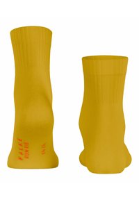 Gelbe Knöchelsocken mit gerippten Bündchen und nahtlosem Design. Mit rotem Text: "FALKE RUNRIB" auf einer Seite, glatte Textur und mittlere Dicke.