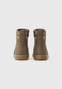 Bottines marron avec des détails floraux et de feuillage brodés, en suède texturé, avec une semelle en caoutchouc robuste et une fermeture éclair sur le côté.