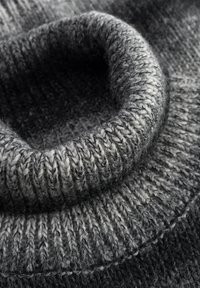 Grau gestrickter Cowl-Pullover mit einer dicken, gerippten Textur. Der Farbverlauf von Dunkelgrau zu Hellgrau erzeugt Tiefe.