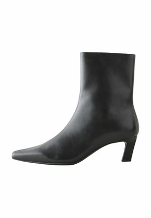 Czarne skórzane botki za kostkę z ostrym noskiem i średnim obcasem. Gładka faktura, elegancki wygląd i minimalistyczny styl.