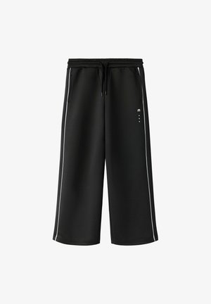 Pantalon noir à jambes larges et coupé, avec taille élastique, cordon, poches latérales zippées et rayures blanches verticales le long des coutures extérieures.
