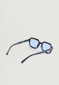 Čierne slnečné okuliare s geometrickým dizajnom a modrými sklíčkami. Rámiky sú štíhle a na vnútornej strane obsahujú diskrétne logo.